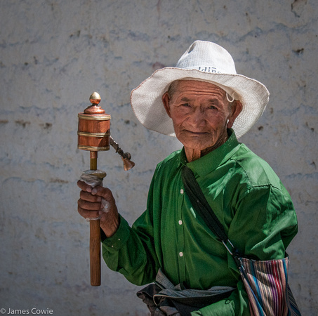 A Tibet lady with a prayer wheel.