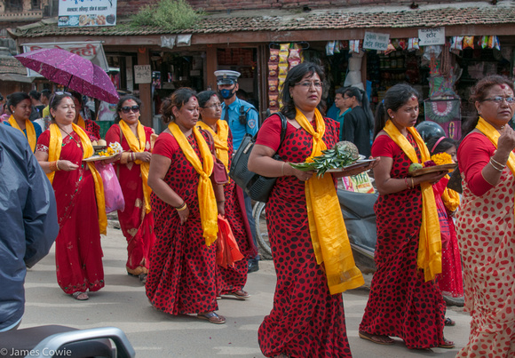 The ladies carrying offerings.
