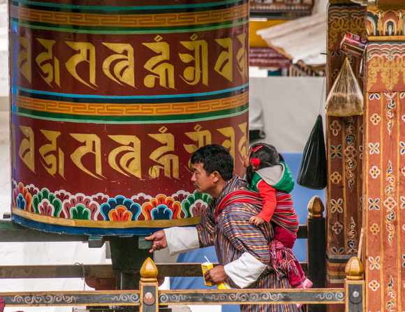 Dad and little girl at prayer wheel.